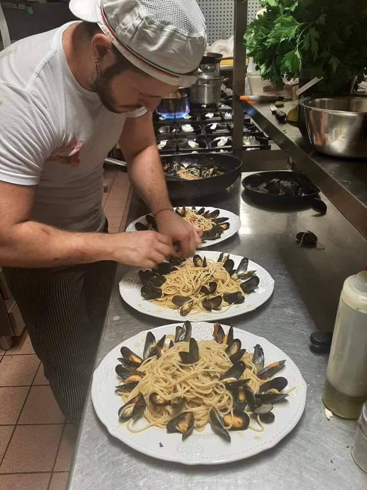 In der Küche des Borsellino werden Spaghetti mit Miesmuscheln auf mehreren Tellern angerichtet