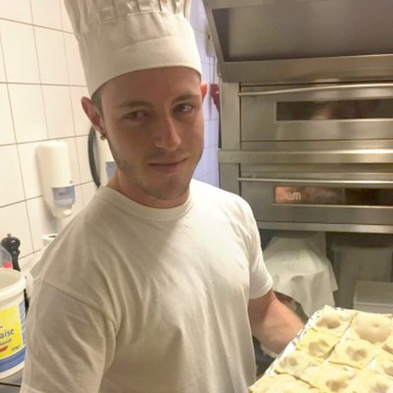 Salvatore Borsellino mit Kochmütze hält ein Blech mit frischen Ravioli